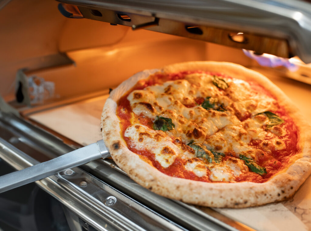 Pizza Pizz.Á được nướng trong lò với lớp phô mai tan chảy hấp dẫn và đế bánh vàng giòn